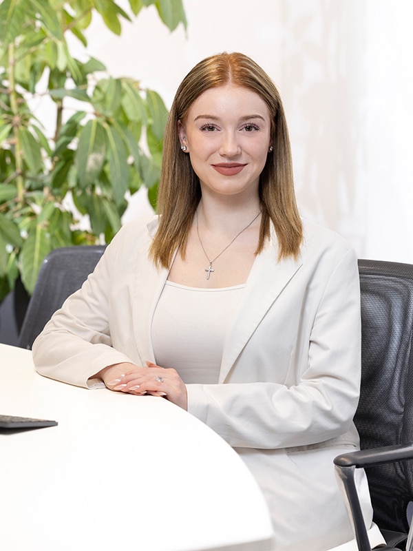 Eine Frau im weißen Blazer sitzt am Tisch. MIZ-Dienstleistungen: Steuerberatung, Wirtschaftsprüfung, Rechtsberatung, Unternehmensberatung.