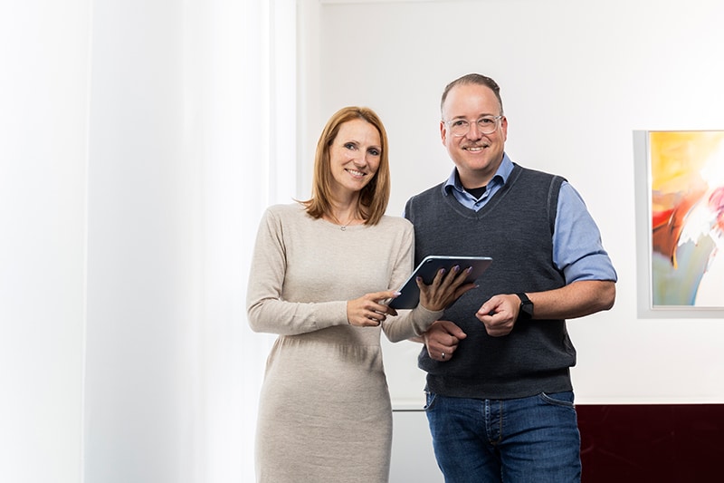 Zwei Geschäftsleute mit Tablet, repräsentieren MIZ in Steuer-, Wirtschafts-, Rechts- und Unternehmensberatung.